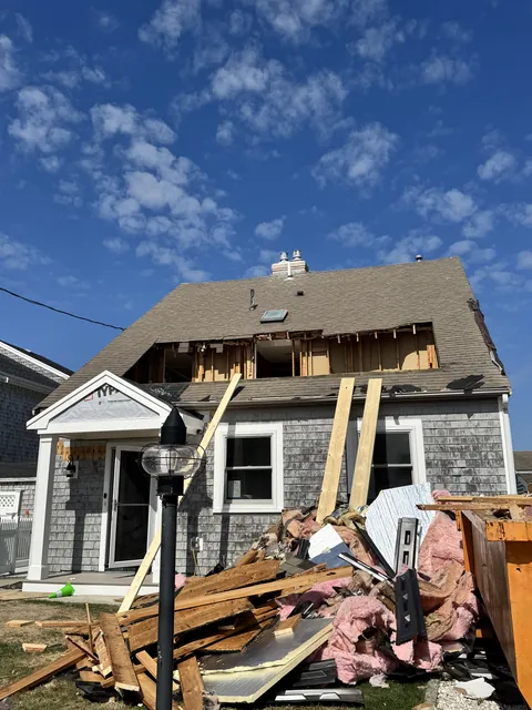 Before: September 15, 2025: the old roof opened up. September 17: a full-width dormer framed and sheathed, with new windows.