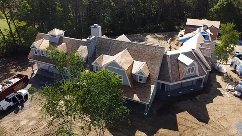 Large shingle home with dormers, seen from the air