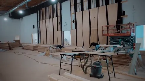 Inside the church project: plywood wall panels going up, with a scissor lift