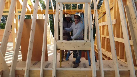 Framer at work inside the wall framing of a new house