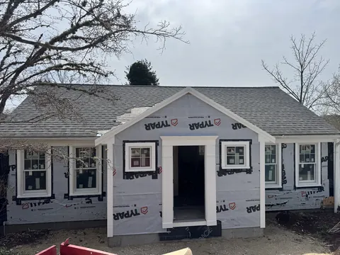 Front addition sheathed and wrapped, with new windows