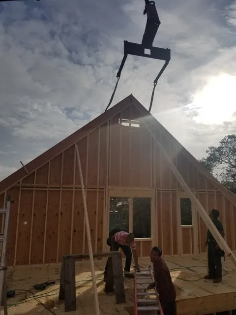 Crew guiding a gable wall off the crane