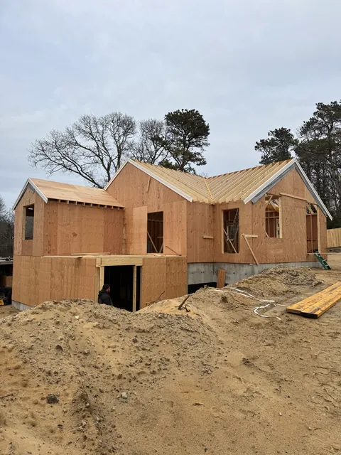 New house framed and sheathed, with two gables and an attached garage