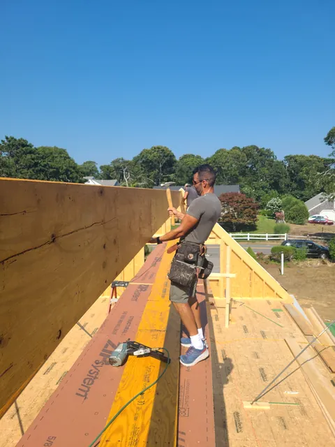 Carpenter working along the roof ridge