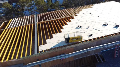 Roof sheathing going down over engineered I-joists, seen from the drone