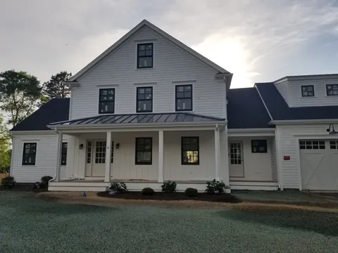 Finished white farmhouse with a full-width front porch