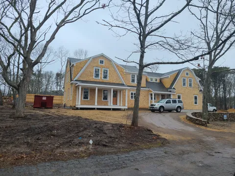 Yellow shingle home with a farmer’s porch, newly built
